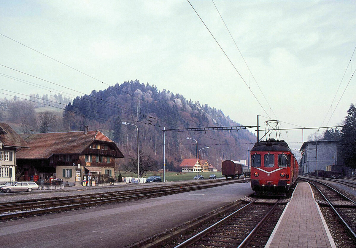 Ramsei im Emmental. Ein roter Zug der damaligen Vereinigten Huttwil Bahnen VHB unterwgs in die Talenge auf der Fahrt nach Langnau. Triebwagen VHB 251 (Baujahr 1966). 31.Dezember 1992 