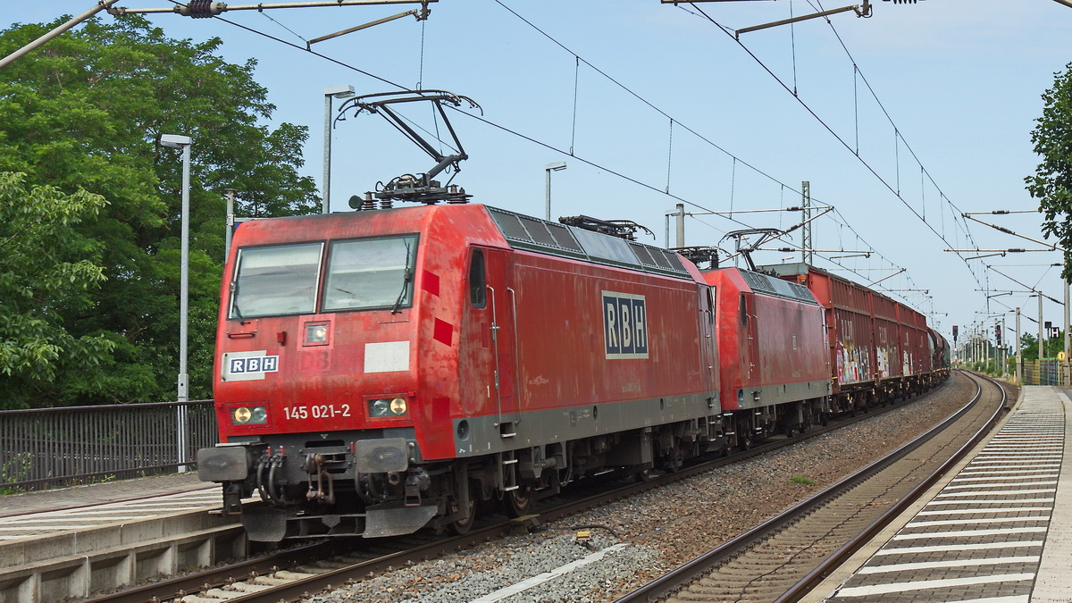 RBH 145 021-2 sowie eine unbekannte BR 145 der DB bei der Durchfahrt durch den Bahnhof Dahlen (Sach) am 25. Juni 2023 mit einem Güterzug.