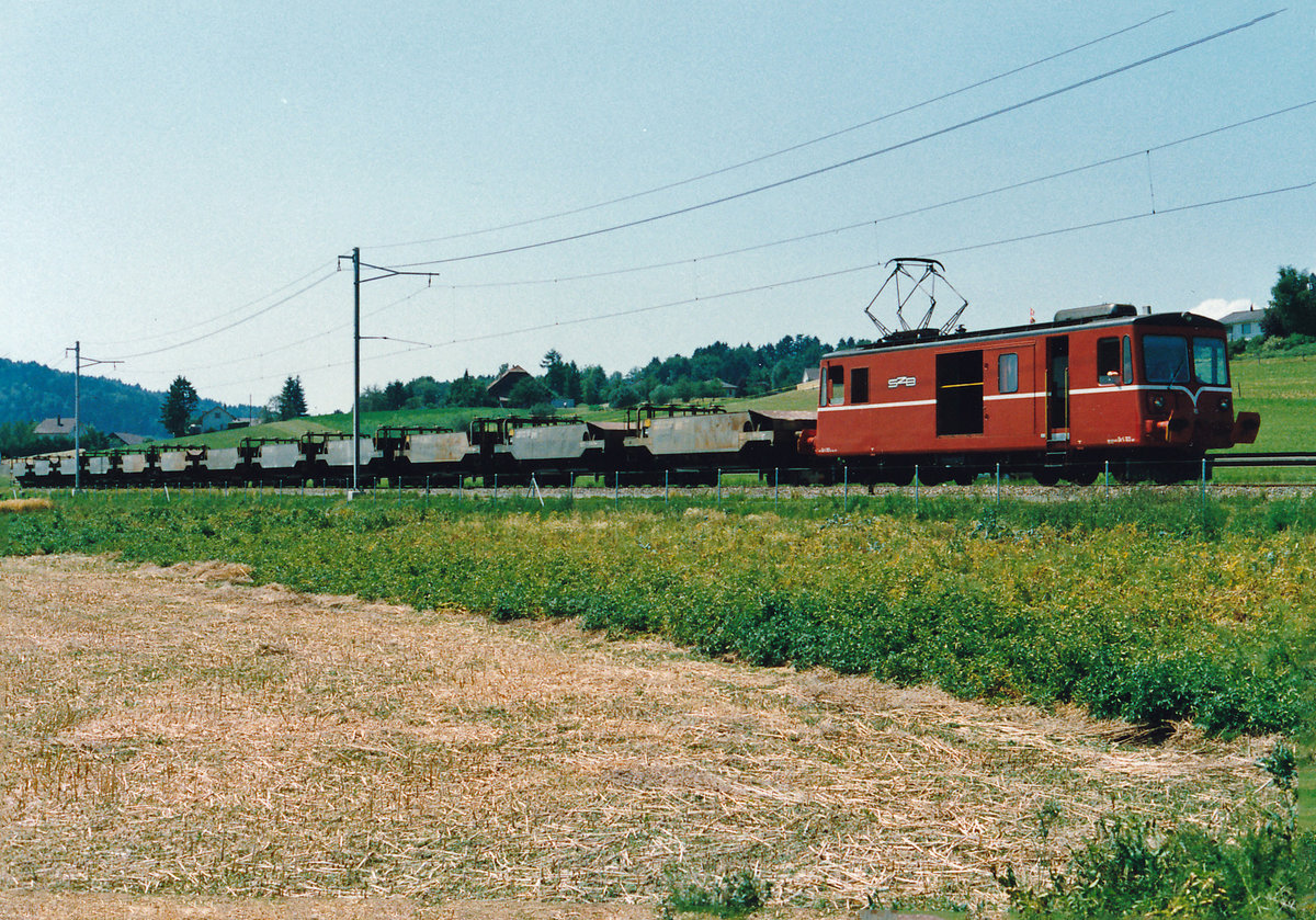 RBS/SZB Regionalverkehr Bern-Solothurn:
Leermaterialzug De 4/4 103 + 12 Schotterwagen auf 24 Rollböcken zwischen Biberist und Lohn-Lüterkofen am 23. Juli 1988.
Foto: Walter Ruetsch