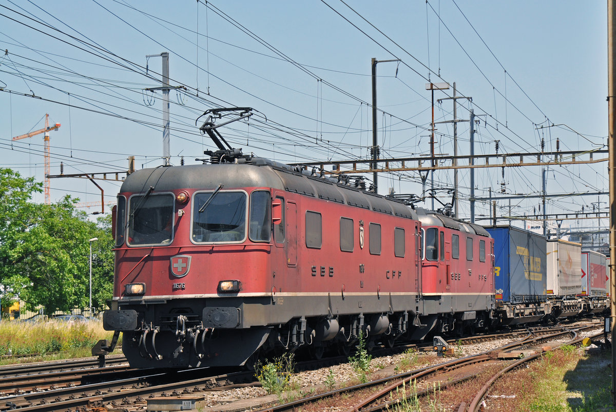 Re 10/10, mit den Loks 11676 und 11339, durchfahren den Bahnhof Pratteln. Das abzweigende Gleis führt auf eine Strasse und in ein Industriegebiet, von wo aus auch diese Aufnahme am 24.06.2016 entstand.