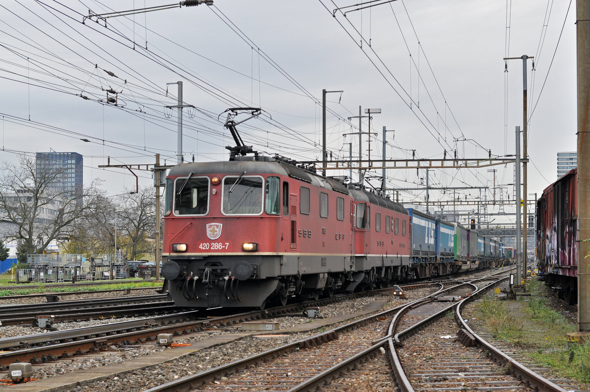 Re 10/10, mit den Loks 420 286-7 und 11664, durchfahren den Bahnhof Pratteln. Die Aufnahme stammt vom 21.11.2017.
