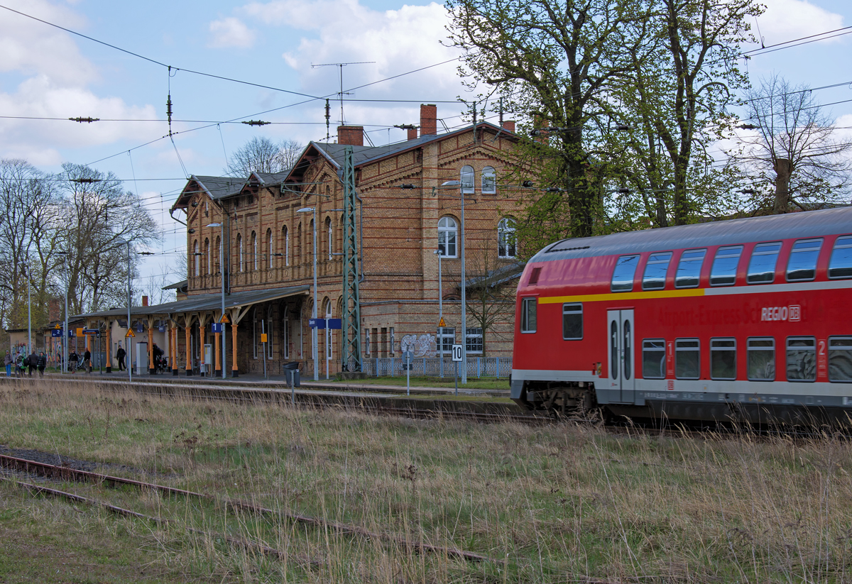 RE 13061 nach Neustrelitz fährt an den Bahnsteig 2 des Bahnhofs Demmin. Im Hintergrund das ehemalige Empfangsgebäude. - 16.04.2015