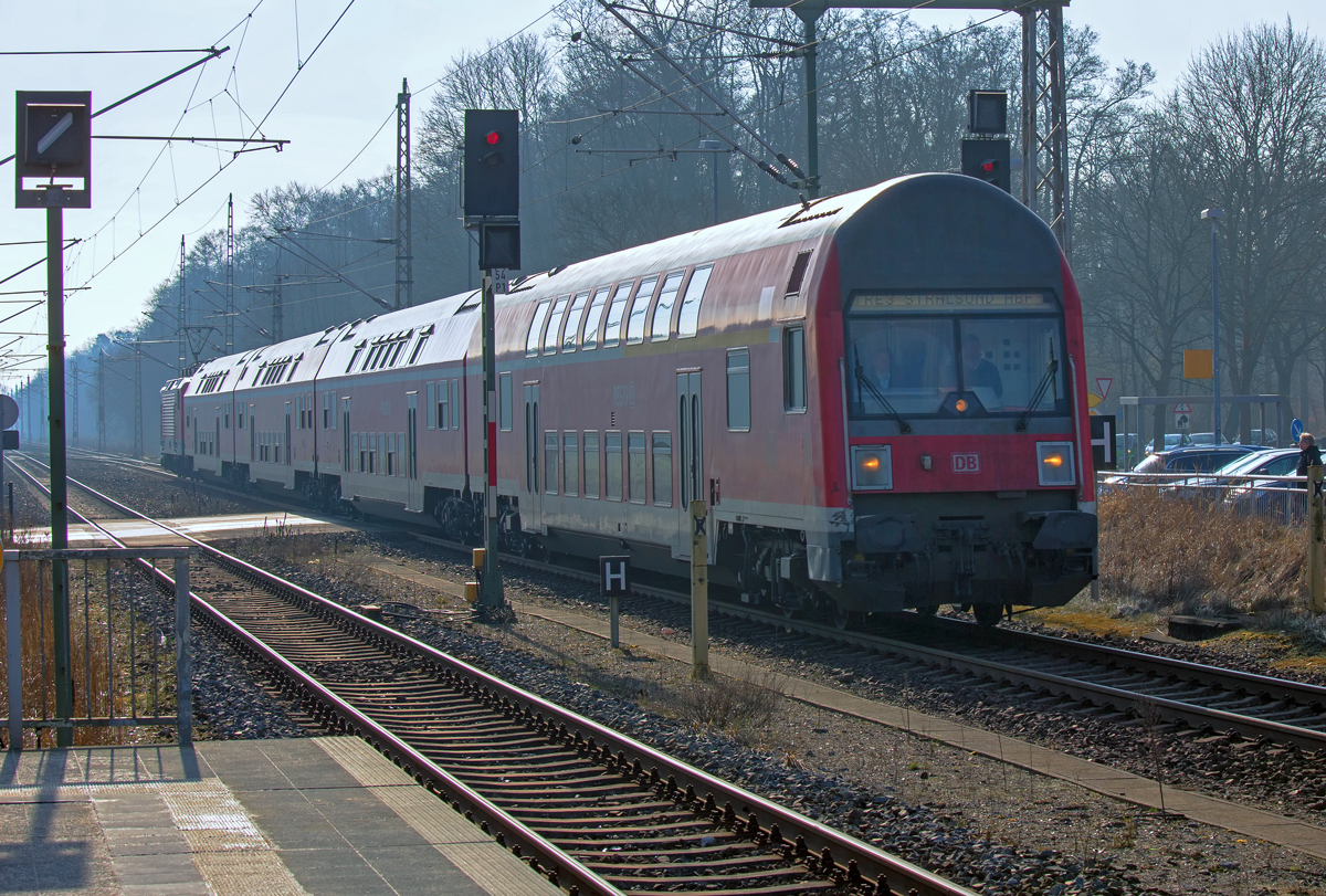RE 18308 (im Gegenlicht) auf der Fahrt nach Stralsund, fährt auf dem Gegengleis an den Bahnsteig des Bahnhofs Jatznick. - 25.02.2015