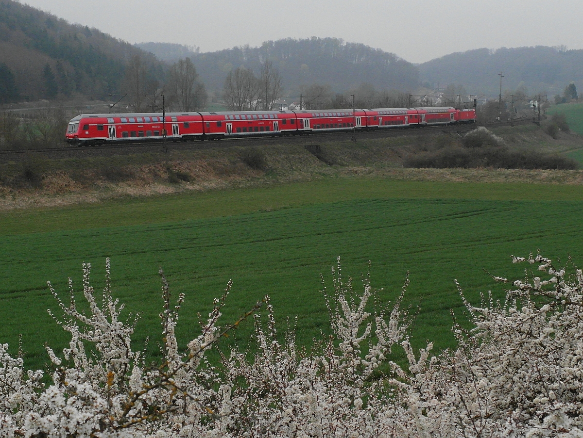 RE 19209 von Neckarelz nach Ulm f�hrt am 05.04.2014 zwischen Urspring und Lonsee an bl�henden Schlehenb�schen und dem in Bezug auf das Wetter entt�uschten Fotografen vorbei.