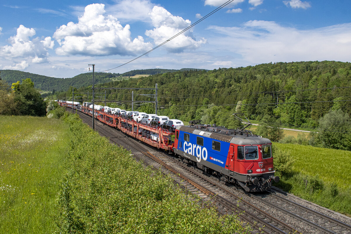 Re 420 247-9 ist mit einem voll beladenen Autozug unterwegs nach Lupfig AG, aufgenommen bei Hornussen AG am 22.05.2023.