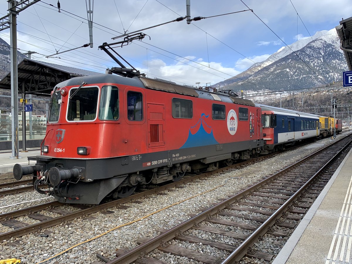 Re 420 294 100 Jahre Zirkus Knie mit einem Messzug im Bahnhof Brig.