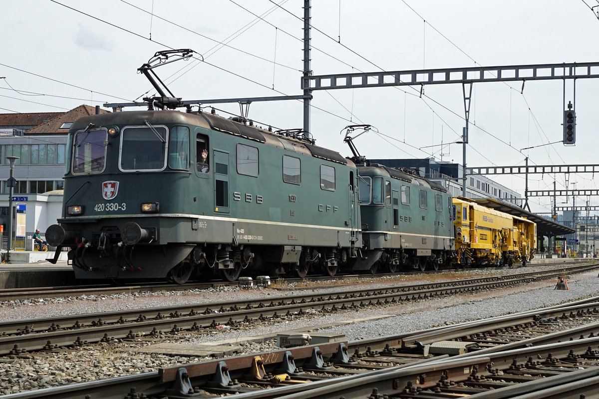 Re 420 330-0.
Re 430 364-0.

Das wird es so schnell nicht wieder geben.

Die Re 4/4ᴵᴵ oder Re 420 sind Universal-Elektrolokomotiven der SBB und kommen dementsprechend vor allen Kategorien von Reisezügen wie auch Güterzügen zum Einsatz. Schwere Züge werden in Doppeltraktion befördert, schwere Güterzüge häufig zusammen mit Re 6/6.

Die Re 4/4ᴵᴵᴵ oder Re 430 sind Elektrolokomotiven der SBB. Sie sind bis auf das Getriebe identisch mit der Re 4/4ᴵᴵ, haben jedoch auf Grund der anderen mechanischen Übersetzung die verlangte Zugkraftspitze für die Rampenstrecken am Gotthard im verlangten Geschwindigkeitsbereich von 80 km/h.

Nur noch bei diese beiden Lokomotiven von SBB CARGO ist der ehemalige grünen Anstrich der SBB erhalten geblieben.

Über das Wochenende vom 18. und 19. April 2020 waren sie gleich als Doppeltraktion in verschiedene Dienste eingeteilt und erinnerten an die alten und schönen Zeiten der Schweizerischen Bundesbahn/SBB-CFF-FFS.

Bahnhofsdurchfahrt Zofingen mit Sonderleistung.

Fotostandort öffentlicher Fussweg entlang des Güterbahnhofs. Bildausschnitt Fotoshop.

Foto: Walter Ruetsch
