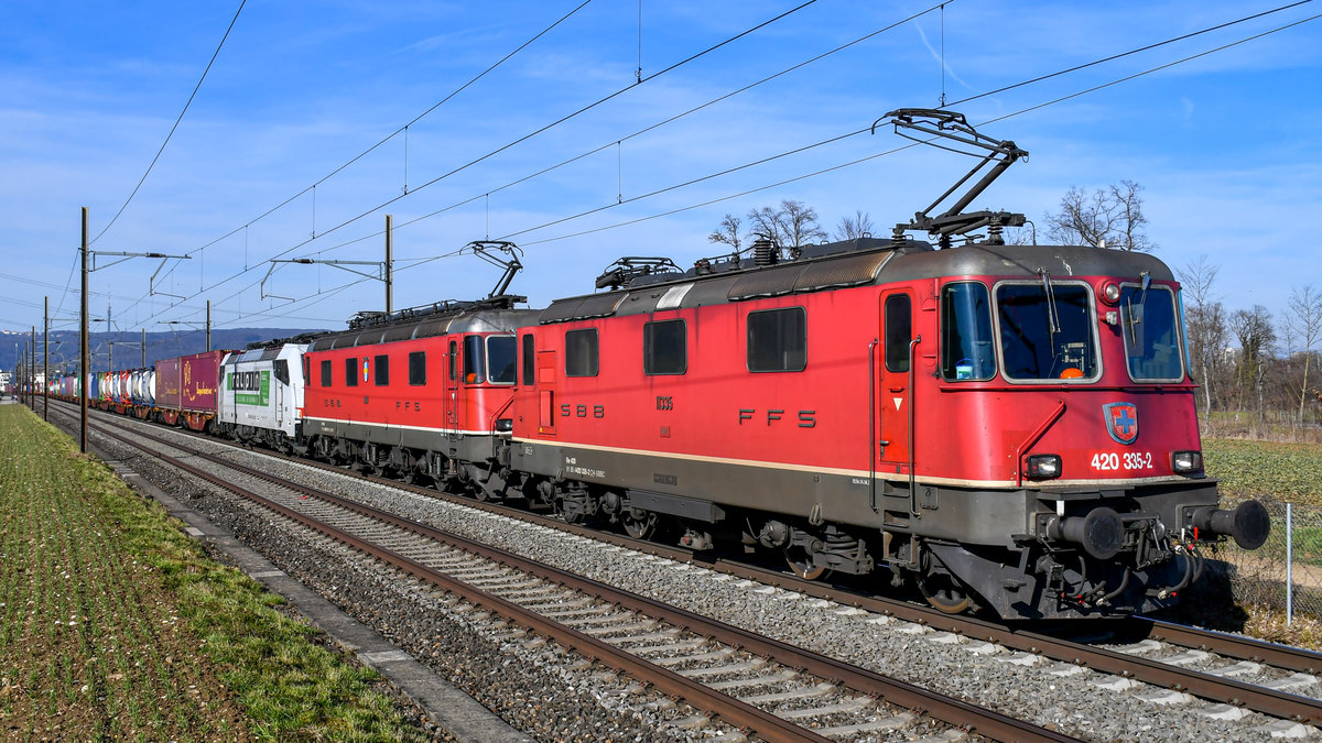 Re 420 335-2 ist zusammen mit Re 6/6 11617  Heerbrugg  bei Frenkendorf in Richtung Olten unterwegs. Im Zug mitgeführt wird 186 901  Axen . Aufgenommen am 20.02.2021.