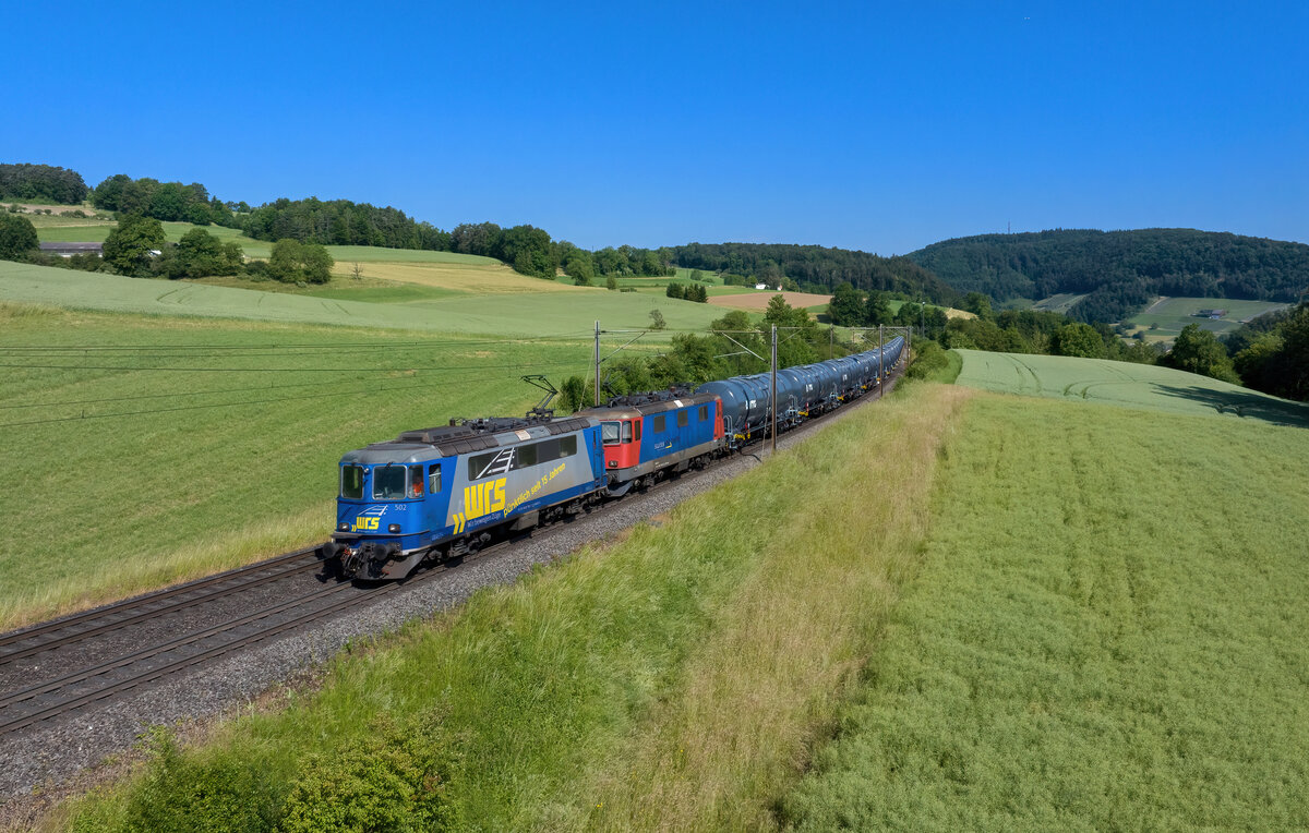 Re 420 502 + Re 421 374 mit einem Kesselzug am 07.06.2023 bei Hornussen.