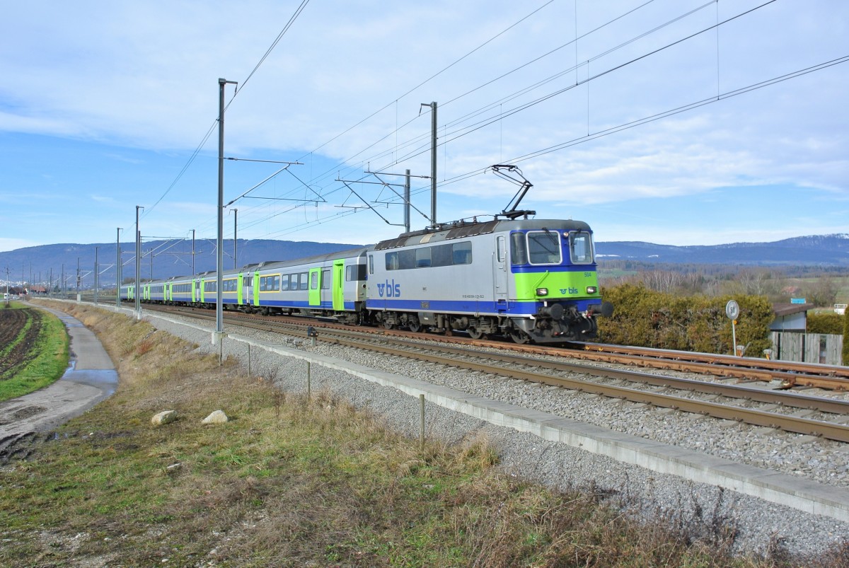 Re 420 504-3 mit ihrem 6-Wagen EWIII Pendel als RE 3929 bei Einfahrt in Ins. Planmssig sind die Pendel AD-A-B-B-B-Bt formiert. Da es jedoch nicht viele Reserve B EWIII hat kommt gelegentlich ein deklassierter A als B zum Einsatz. So auch in diesem Pendel; AD-A-A deklassiert-B-B-Bt, 12.01.2015.