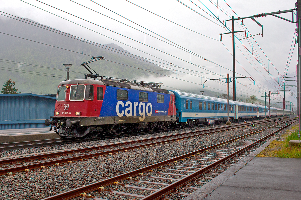 Re 421 371-6 braust am frühen Morgen bei strömendem Regenwetter mit dem EN 466 aus Budapest nach Zürich HB bei Bilten vorüber.Bild vom 1.5.2015