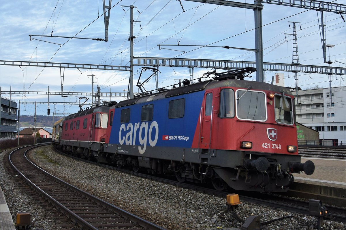Re 421 374-0 zieht zusammen mit Re 6/6 11644  Cornaux  ihren Güterzug am 08.03.2018 durch Brugg AG in Richtung Basel.