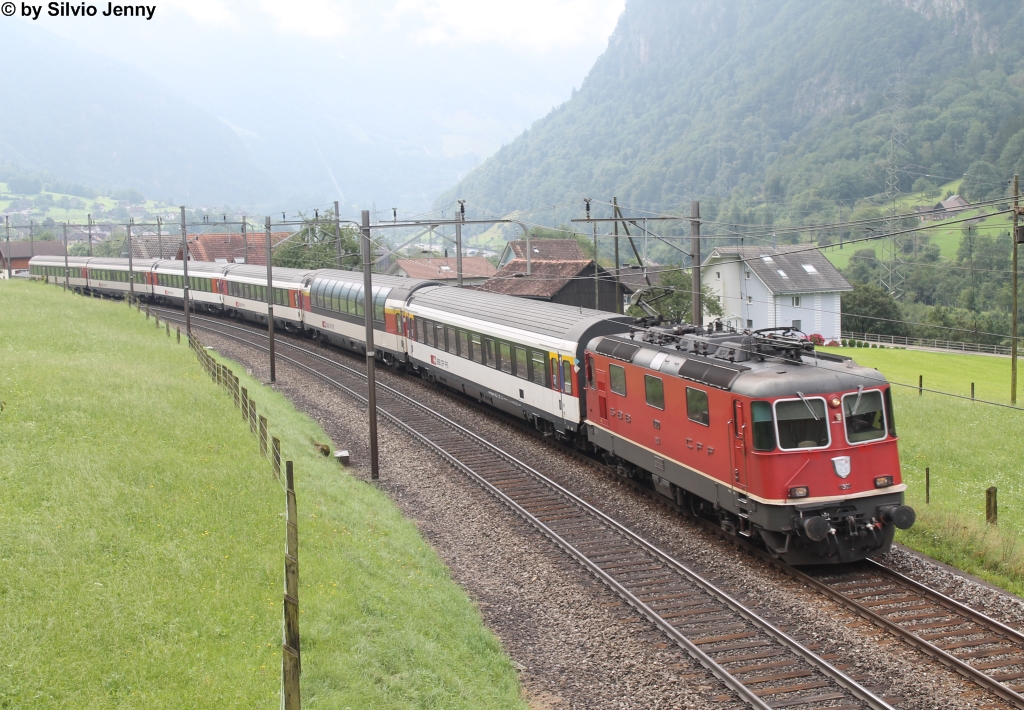 Re 4/4'' 11300 am 31.7.2014 zwischen Amsteg-Silenen und Erstfeld mit dem IR 2176 Richtung Basel. Die Schnellzüge, bzw. IR am Gotthard waren lange Zeit für ihre bunte Wagenzusammensetzung bekannt. Seit nun aber auch die Panorama-Wagen das refit durchlaufen, verkehren die IR am Gotthard farblich wieder einheitlich. 