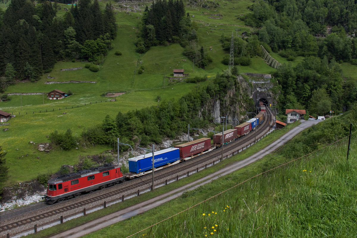 Re 4/4 11663 schiebt einen KLV durch die Wattinger Kurve die Gotthard-Nordrampe hinauf, aufgenommen am 25. Mai 2016.