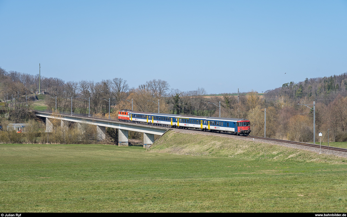 Re 4/4 II 11108 bringt am 29. März 2019 einen Extrazug für Militärangehörige, bestehend aus einem HVZ-Pendel der Regio-S-Bahn Basel, von Bure nach Basel. Hier kurz vor der Einmündung der ausschliesslich Militärtransporten dienenden Strecke Courtemaîche - Bure in die Strecke Delémont - Delle bei Courtemaîche. 