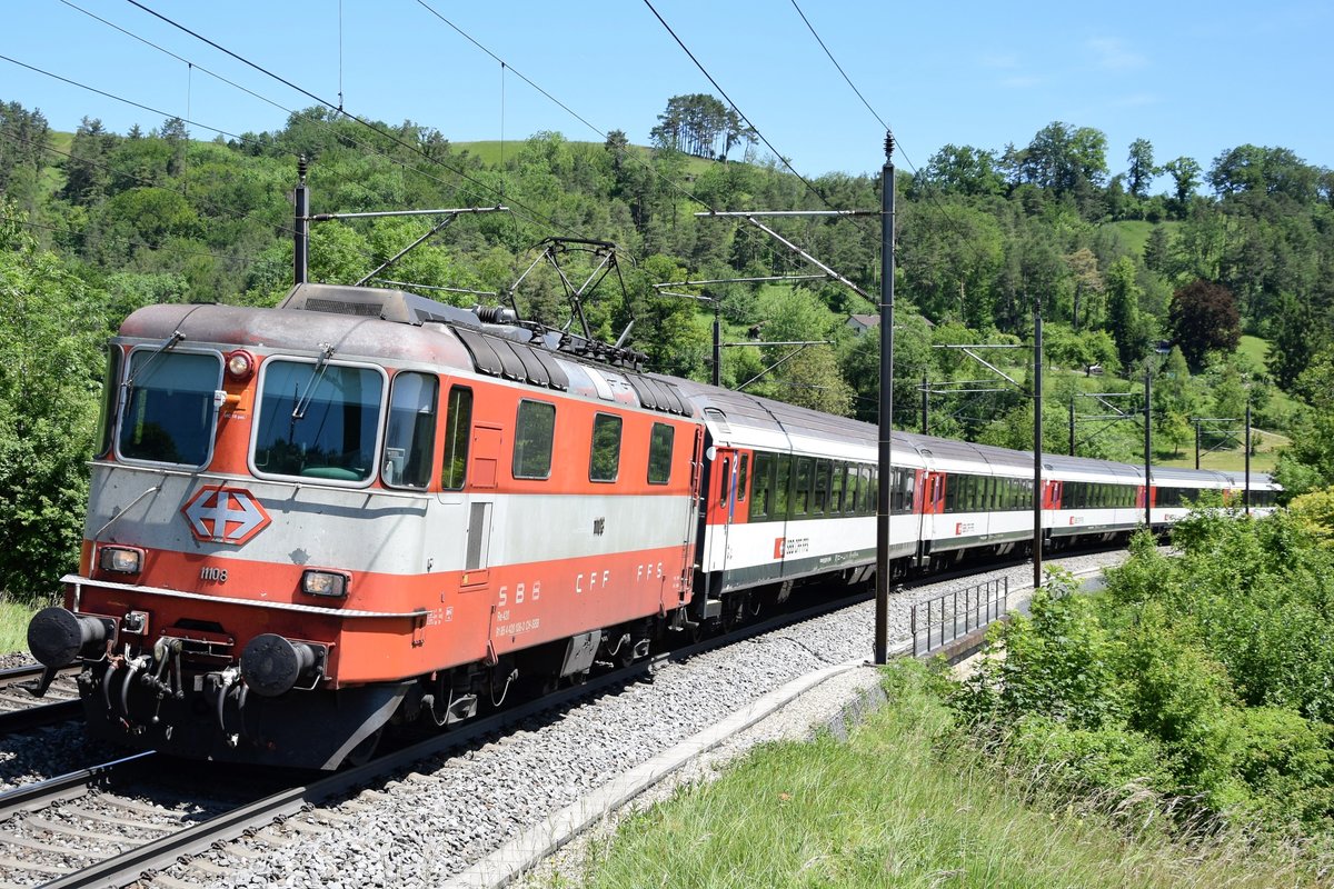 Re 4/4 II 11108 in Swiss Express-Farben zieht den IR 36 (Brugg ab 12:02 Uhr) bei Villnachern AG in Richtung Basel. Aufgenommen am 08.06.2019.