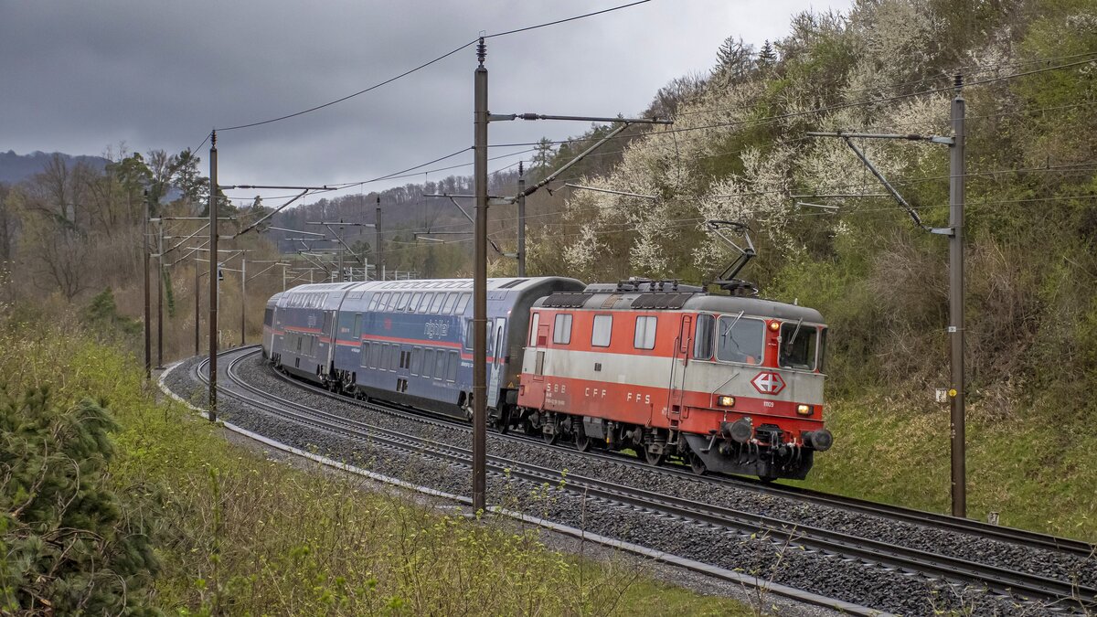 Re 4/4 II 11109 ist mit dem NJ aus Hamburg bei Villnachern AG unterwegs  nach Zürich HB. Aufgenommen bei sehr dürftigem Wetter am 01.04.2023.