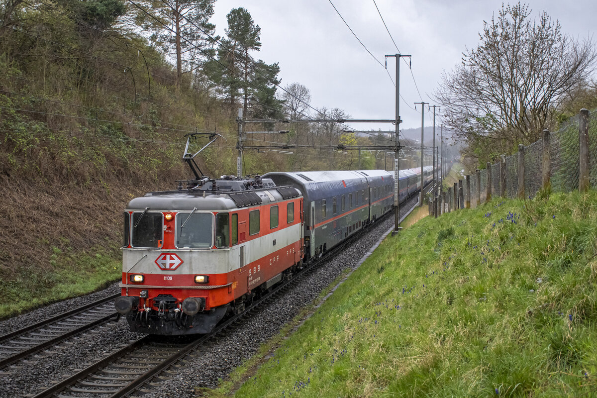 Re 4/4 II 11109 ist mit dem NJ aus Hamburg unterwegs nach Zürich HB.  Aufgenommen bei sehr dürftigem Wetter am 01.04.2023 kurz vor Turgi AG.