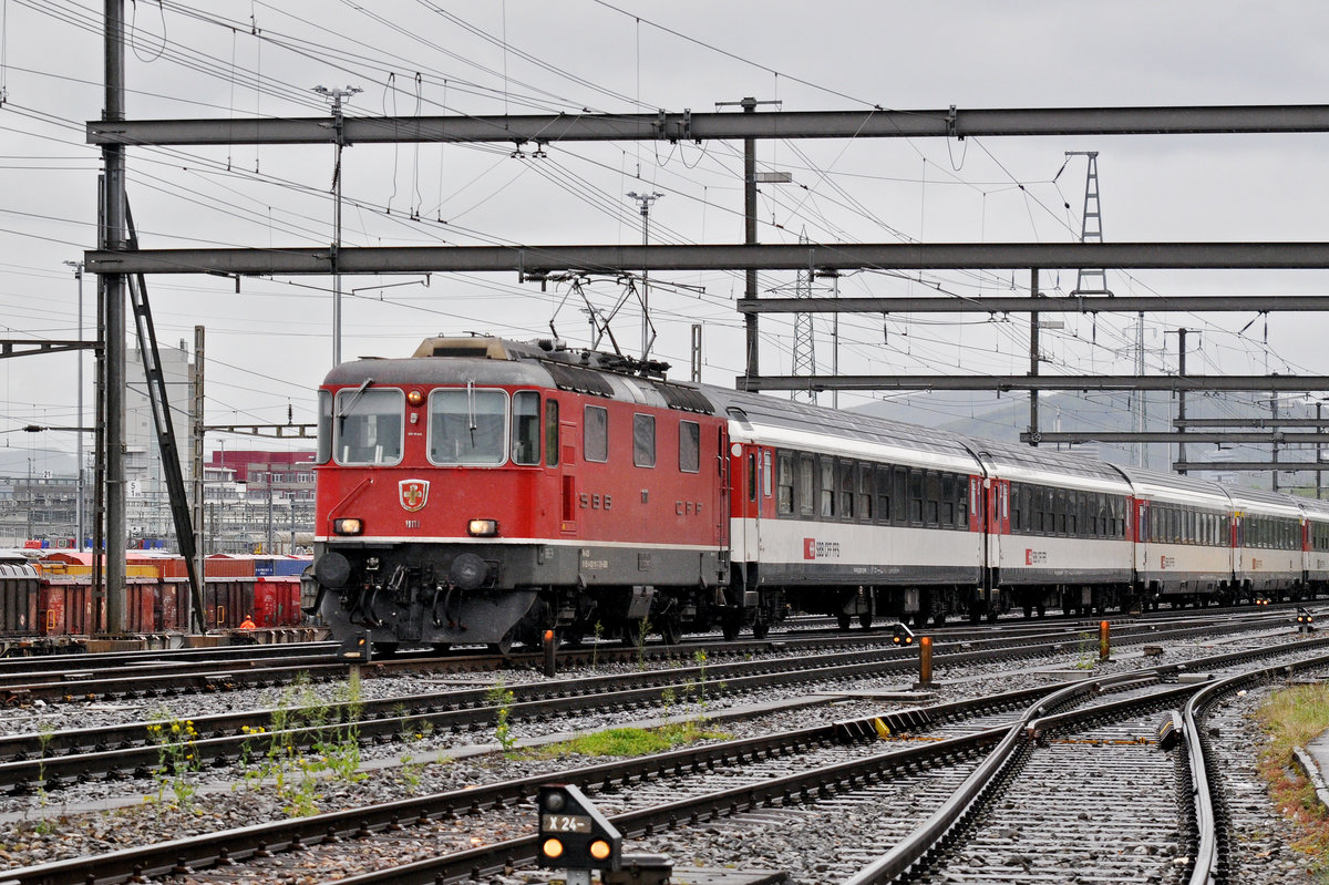 Re 4/4 II 11111 durchfährt bei regnerischem Wetter den Bahnhof Muttenz. Die Aufnahme stammt vom 01.05.2017.