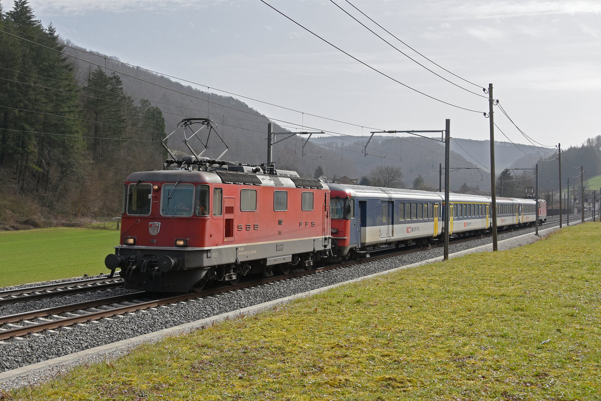 Re 4/4 II 11112, BDt 50 85 82-34 905-8 und die Re 4/4 II 11141 fahren Richtung Bahnhof Gelterkinden. Die Aufnahme stammt vom 26.02.2020.