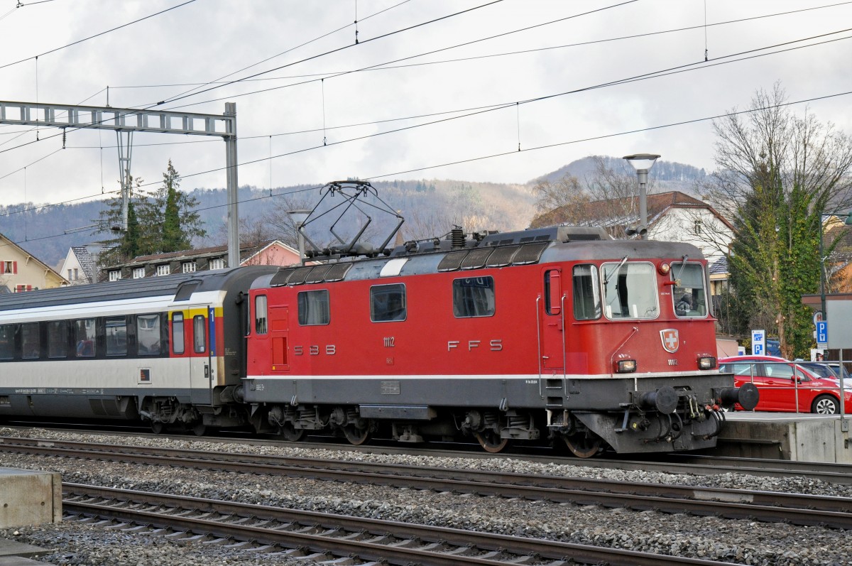 Re 4/4 II 11112 durchfährt den Bahnhof Sissach. Die Aufnahme stammt vom 23.11.2015.