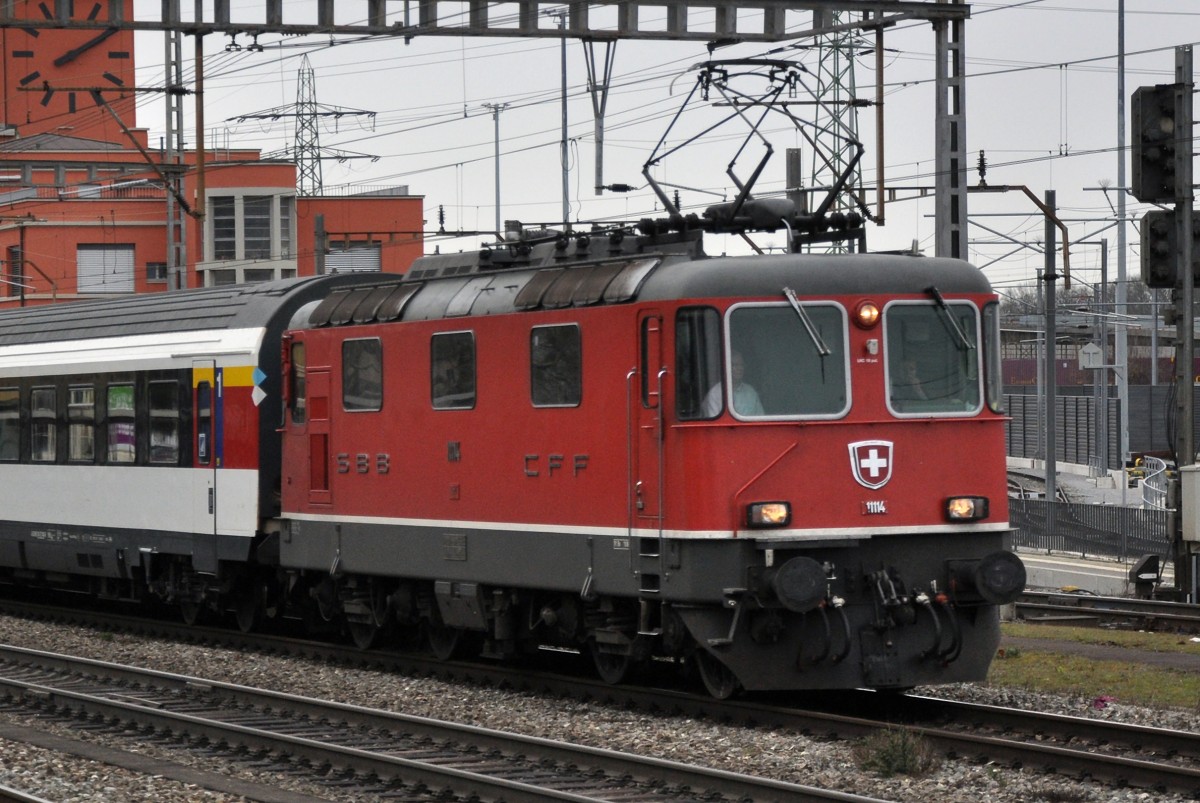 Re 4/4 II 11114 durchfährt den Bahnhof Muttenz. Die Aufnahme stammt vom 14.02.2014.