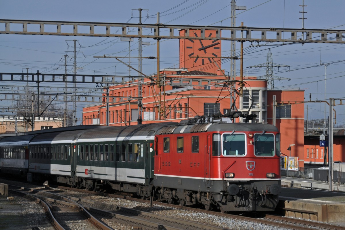 Re 4/4 II 11115 durchfährt den Bahnhof Muttenz. Die Aufnahme stammt vom 22.12.2014.