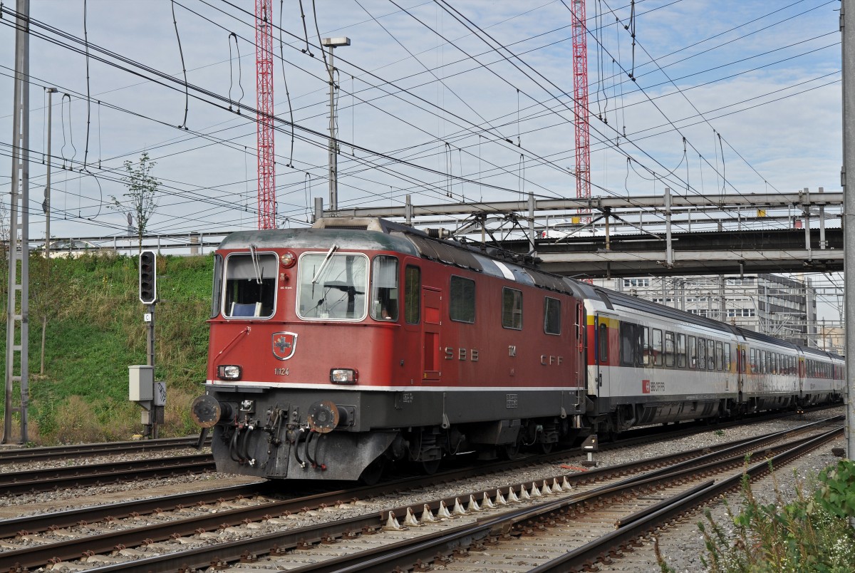 Re 4/4 II 11124 durchfährt den Bahnhof Muttenz. Die Aufnahme stammt vom 28.08.2015.