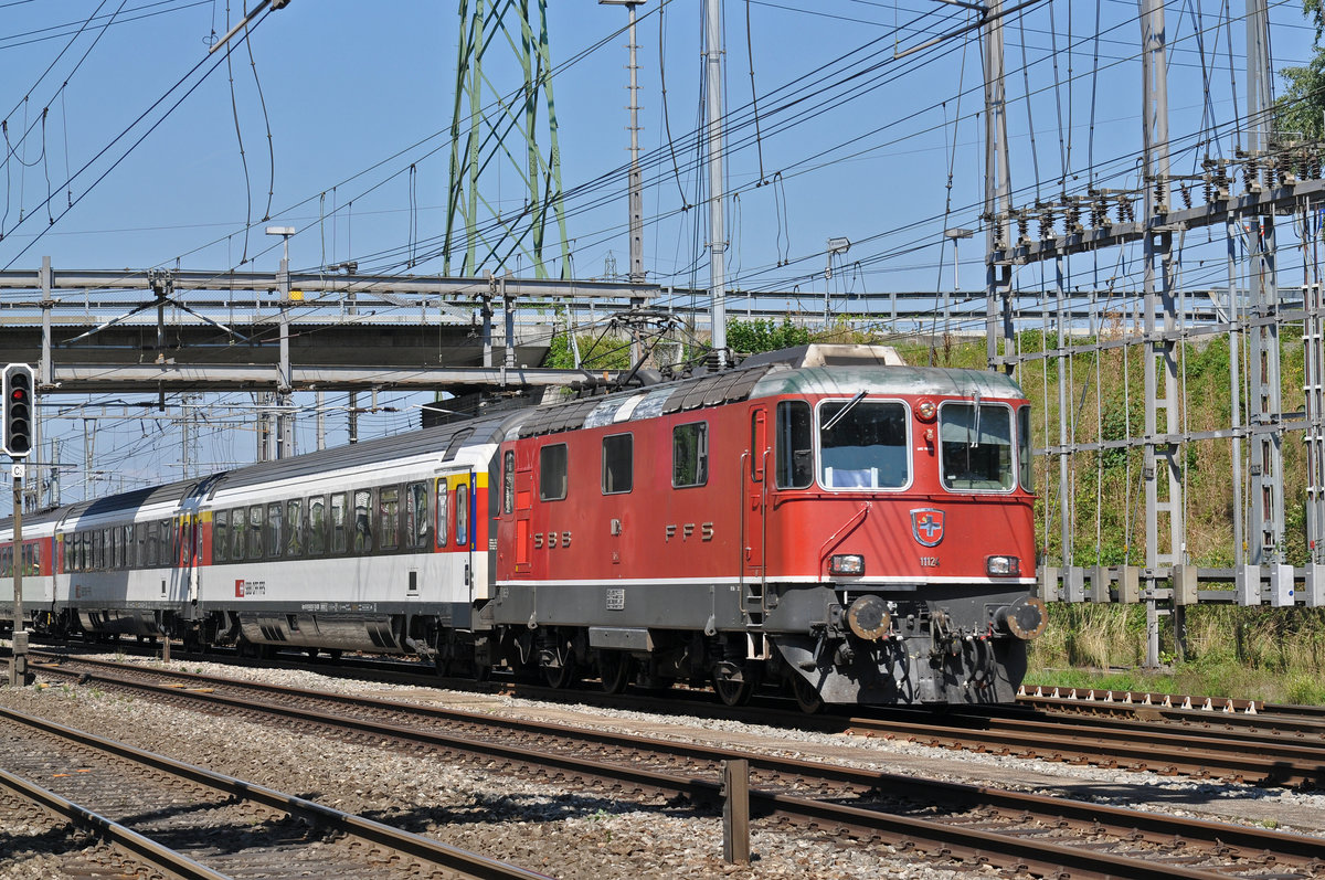 Re 4/4 II 11124 durchfährt den Bahnhof Muttenz. Die Aufnahme stammt vom 21.08.2015.