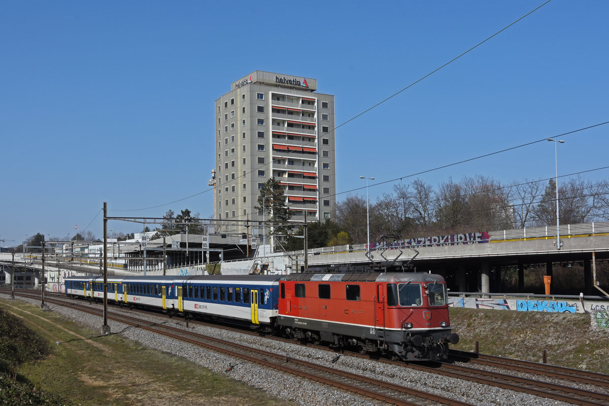 Re 4/4 II 11124 fährt Richtung Bahnhof Muttenz. Die Aufnahme stammt vom 25.02.2021.