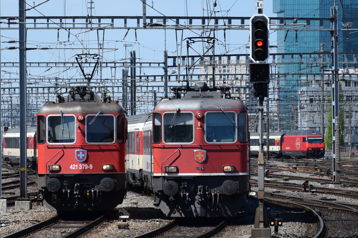 Re 4/4 II 11124 und Re 421 379-9 und im Hintergrund die Re 460 041-7  Mendrisiotto  im Einfahrtbereich des HB Zürich am 18.04.2018