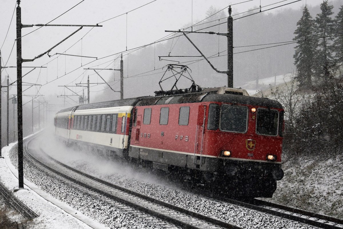 Re 4/4 II 11126 mit ihrem Interregio bei Schneefall unterwegs nach Zürich HB aufgenommen zwischen Schinznach-Dorf und Villnachern in Richtung Brugg am 05.01.2019.