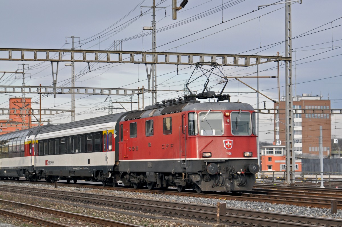 Re 4/4 II 11128 durchfährt den Bahnhof Muttenz. Die Aufnahme stammt vom 31.01.2015.
