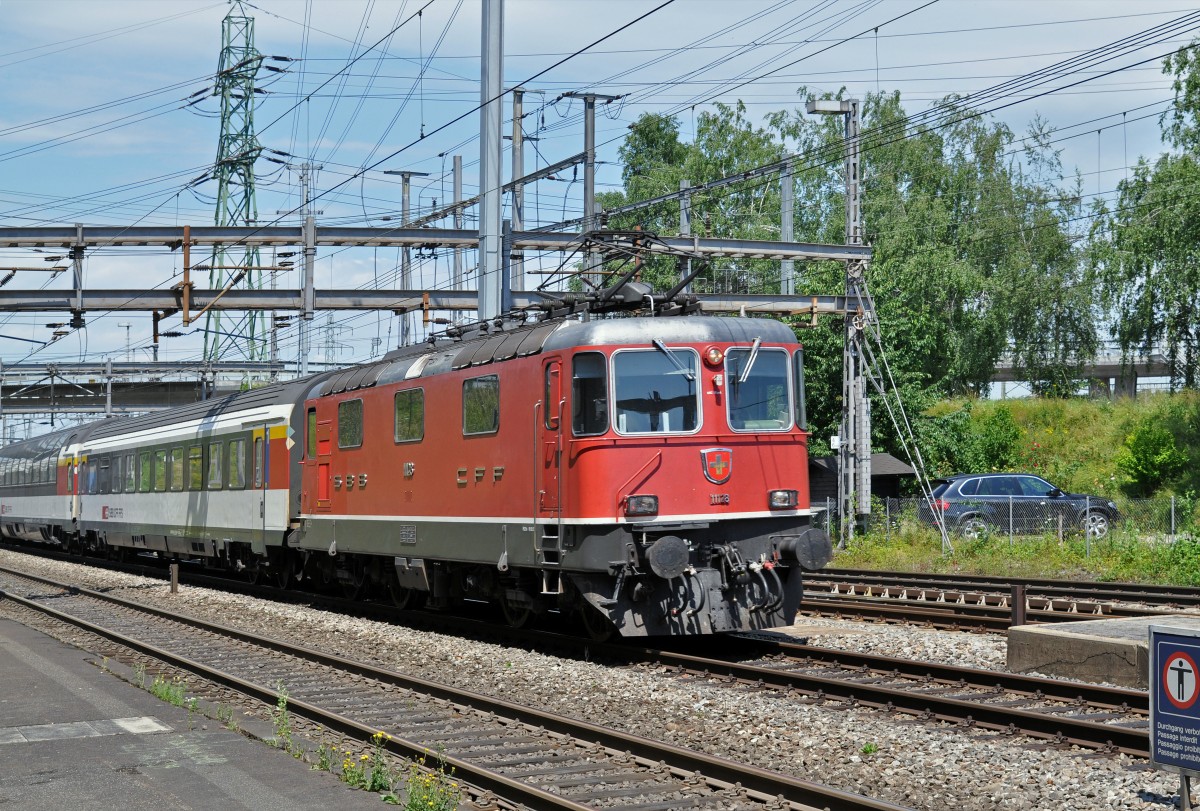 Re 4/4 II 11128 durchfährt den Bahnhof Muttenz. Die Aufnahme stammt vom 27.06.2015.