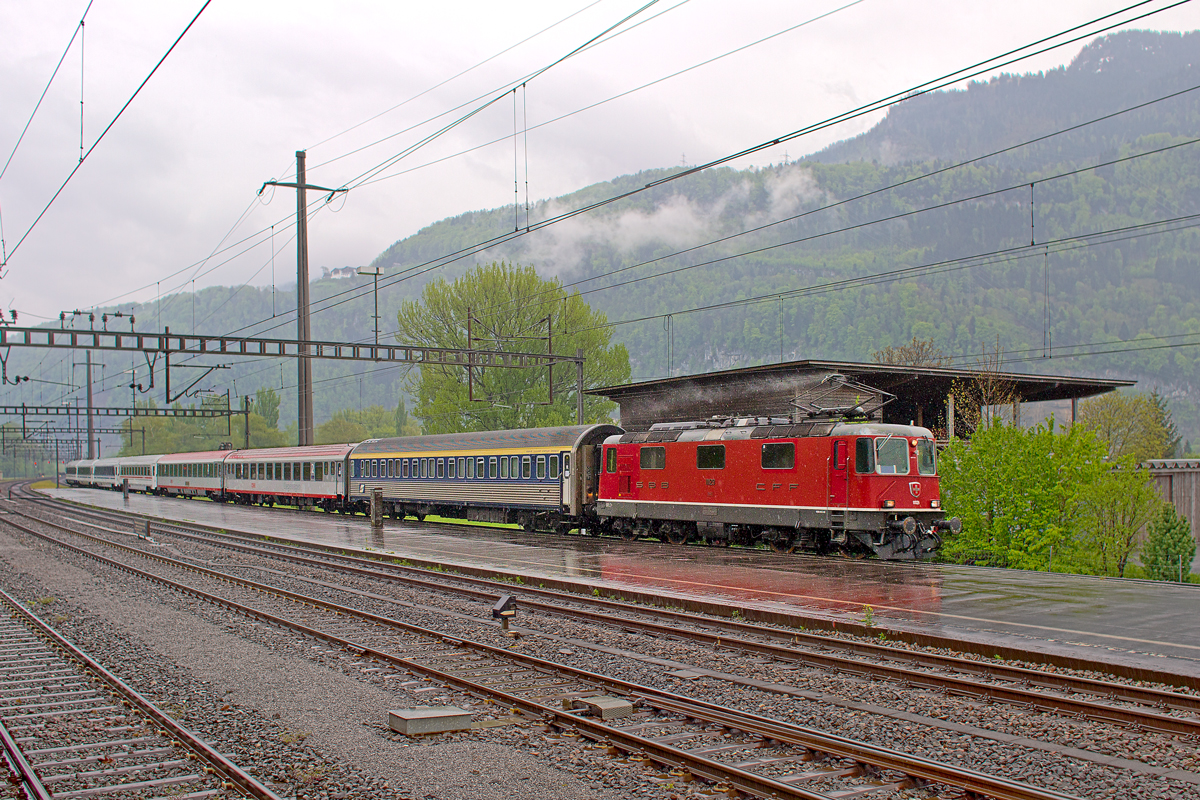 Re 4/4 II 11129 braust bei strömendem Regen mit dem EN 464 aus Beograd nach Zürich HB bei Weesen vorüber.Bild vom 1.5.2015