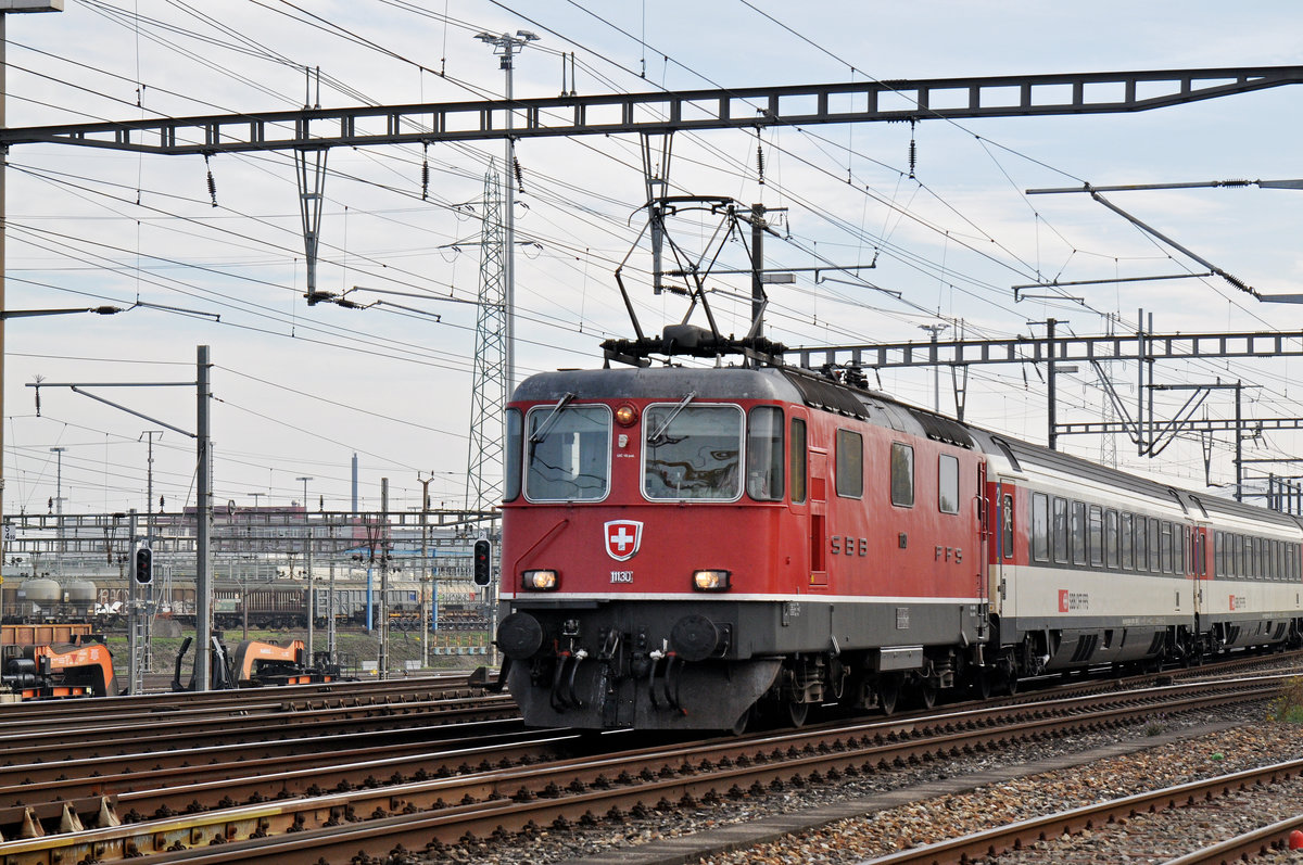 Re 4/4 II 11130 durchfährt den Bahnhof Muttenz. Die Aufnahme stammt vom 28.10.2015.