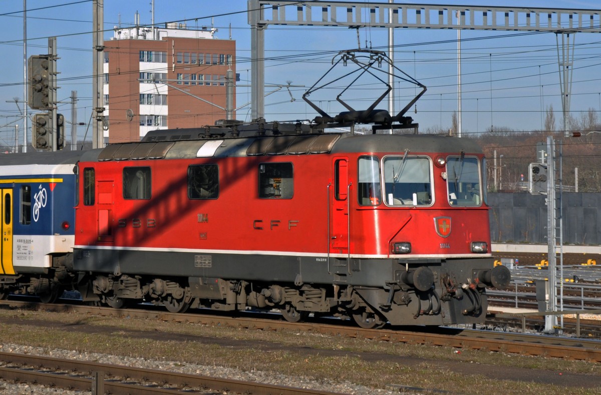 Re 4/4 II 11144 durchfährt den Bahnhof Muttenz. Die Aufnahme stammt vom 16.12.2013.