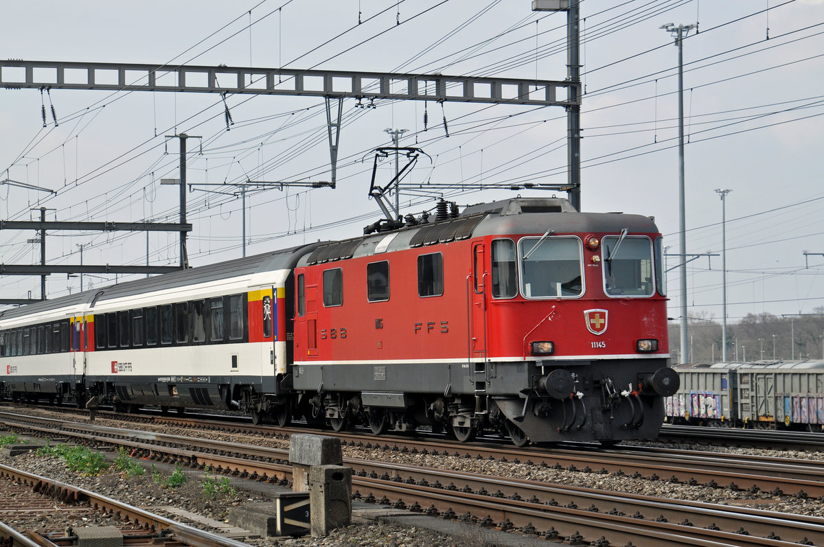 Re 4/4 II 11145 durchfährt den Bahnhof Muttenz. Die Aufnahme stammt vom 24.03.2016.