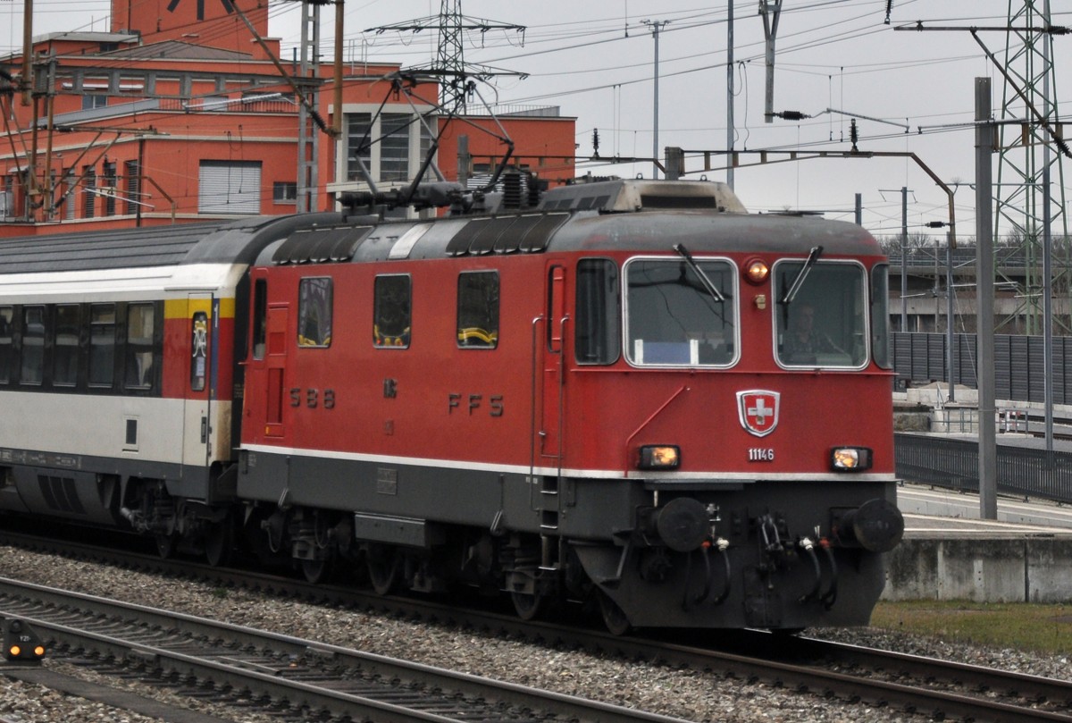 Re 4/4 II 11146 durchfährt den Bahnhof Muttenz. Die Aufnahme stammt vom 14.02.2014.