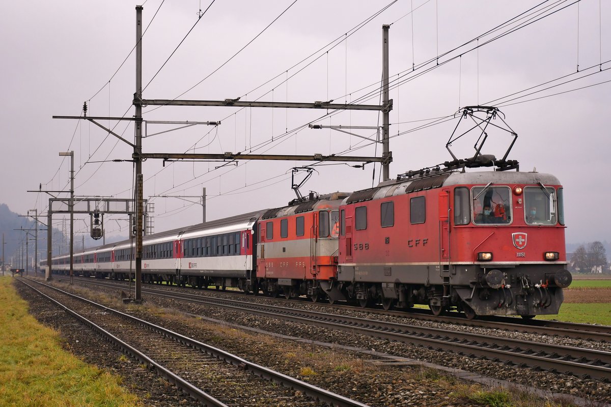 Re 4/4 II 11151 ist gemeinsam mit 11109 unterwegs mit einem Leermaterialzug (bis auf einen EW IV A alles B50), aufgenommen kurz vor Dottikon AG am 21.12.2020.