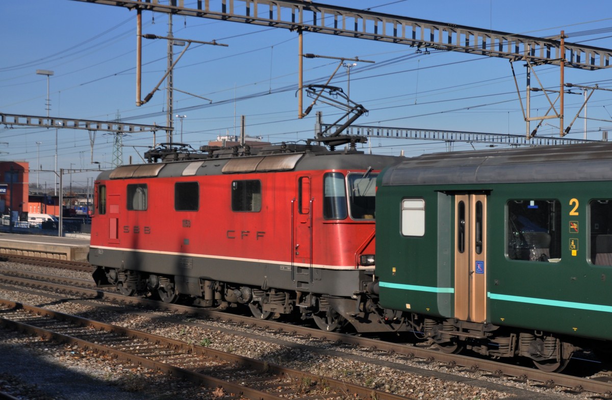 Re 4/4 II 11153 durchfährt den Bahnhof Muttenz. Die Aufnahme stammt vom 09.12.2013.