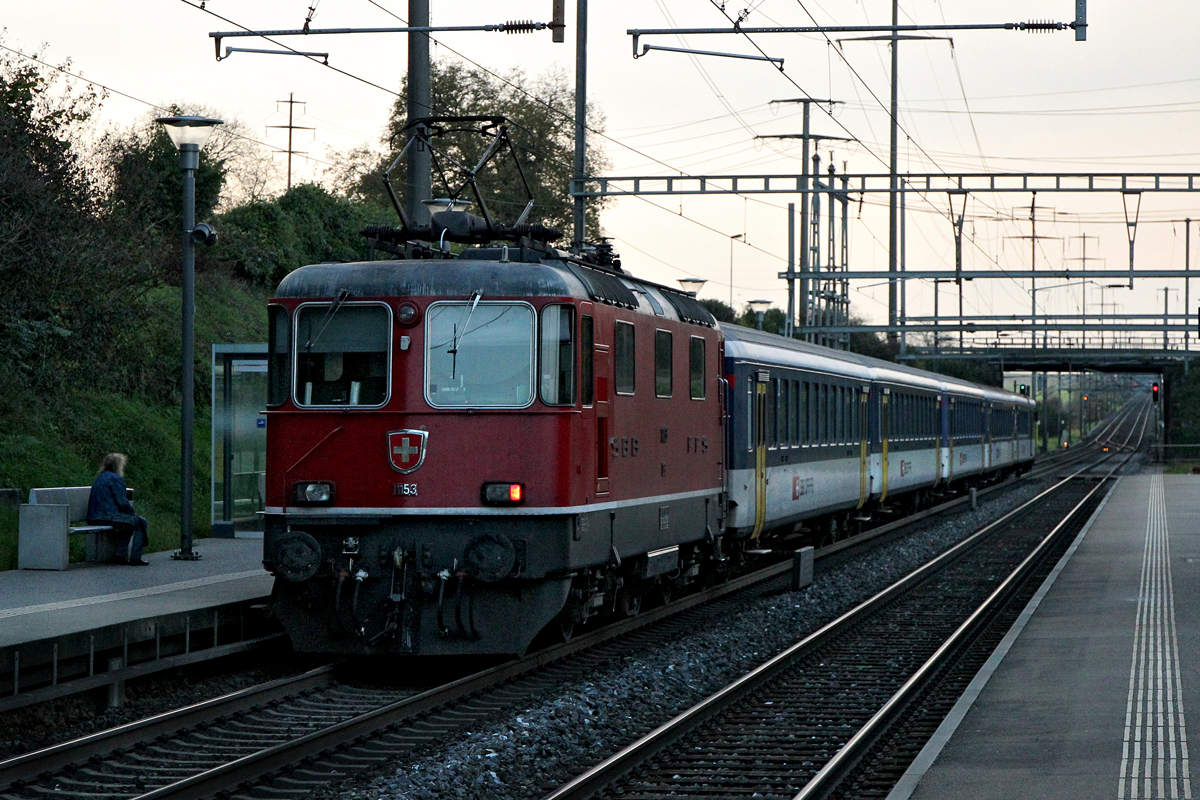 Re 4/4 II 11153 schiebt spätabends eine EW II Wagengarnitur  bei Mumpf vorbei Richtung Basel.Bild vom 24.10.2014