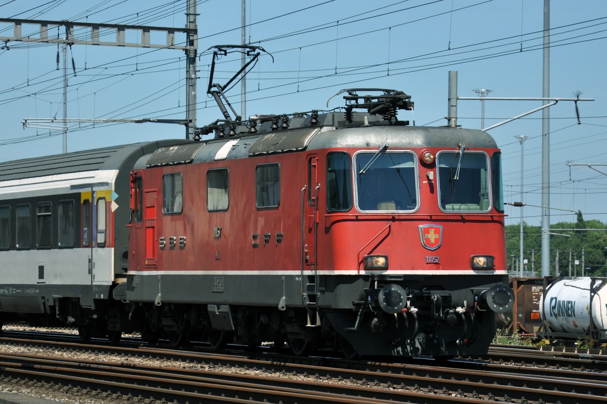 Re 4/4 II 11157 durchfährt den Bahnhof Muttenz. Die Aufnahme stammt vom 03.07.2014.