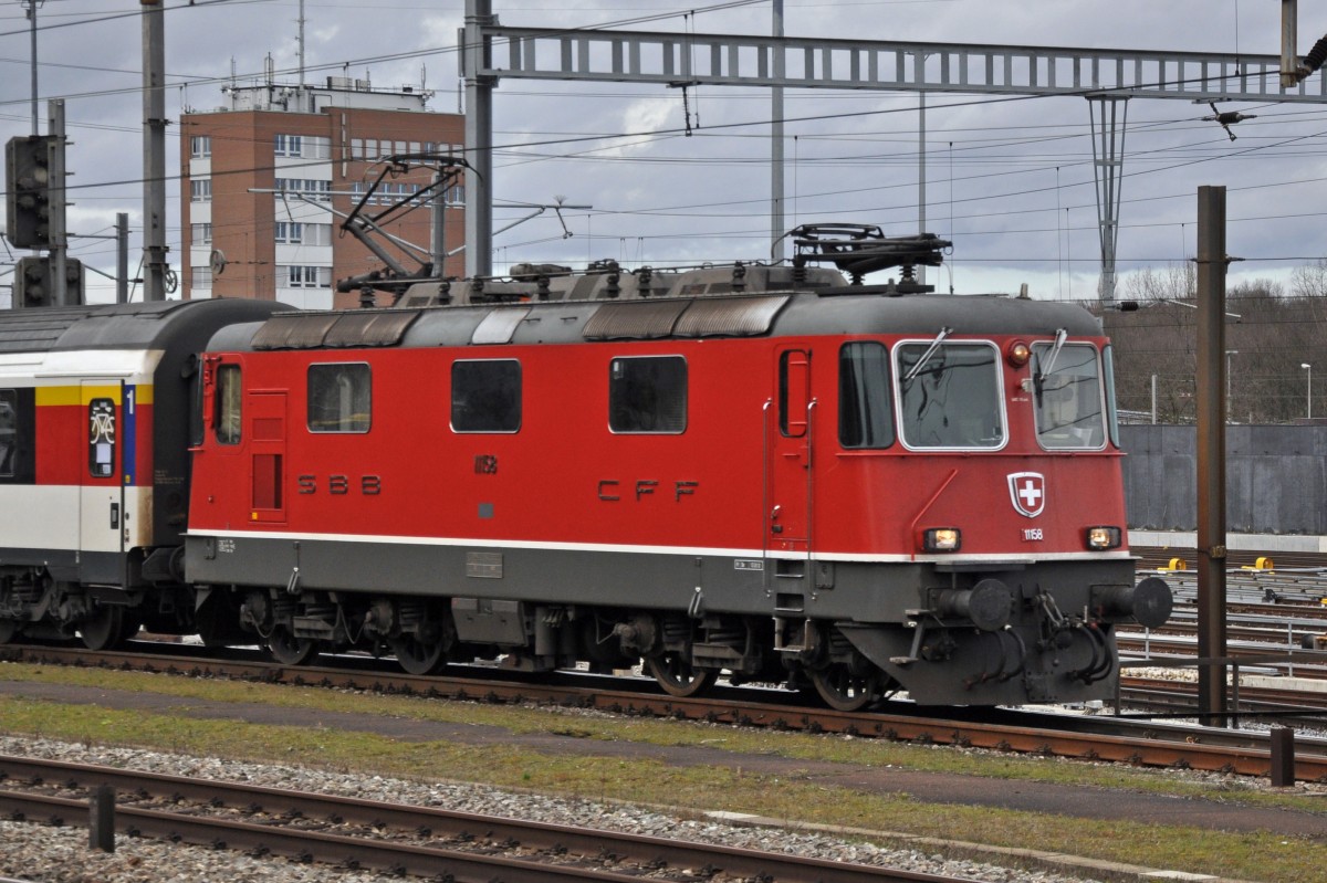 Re 4/4 II 11158 durchfährt den Bahnhof Muttenz. Die Aufnahme stammt vom 16.02.2014.