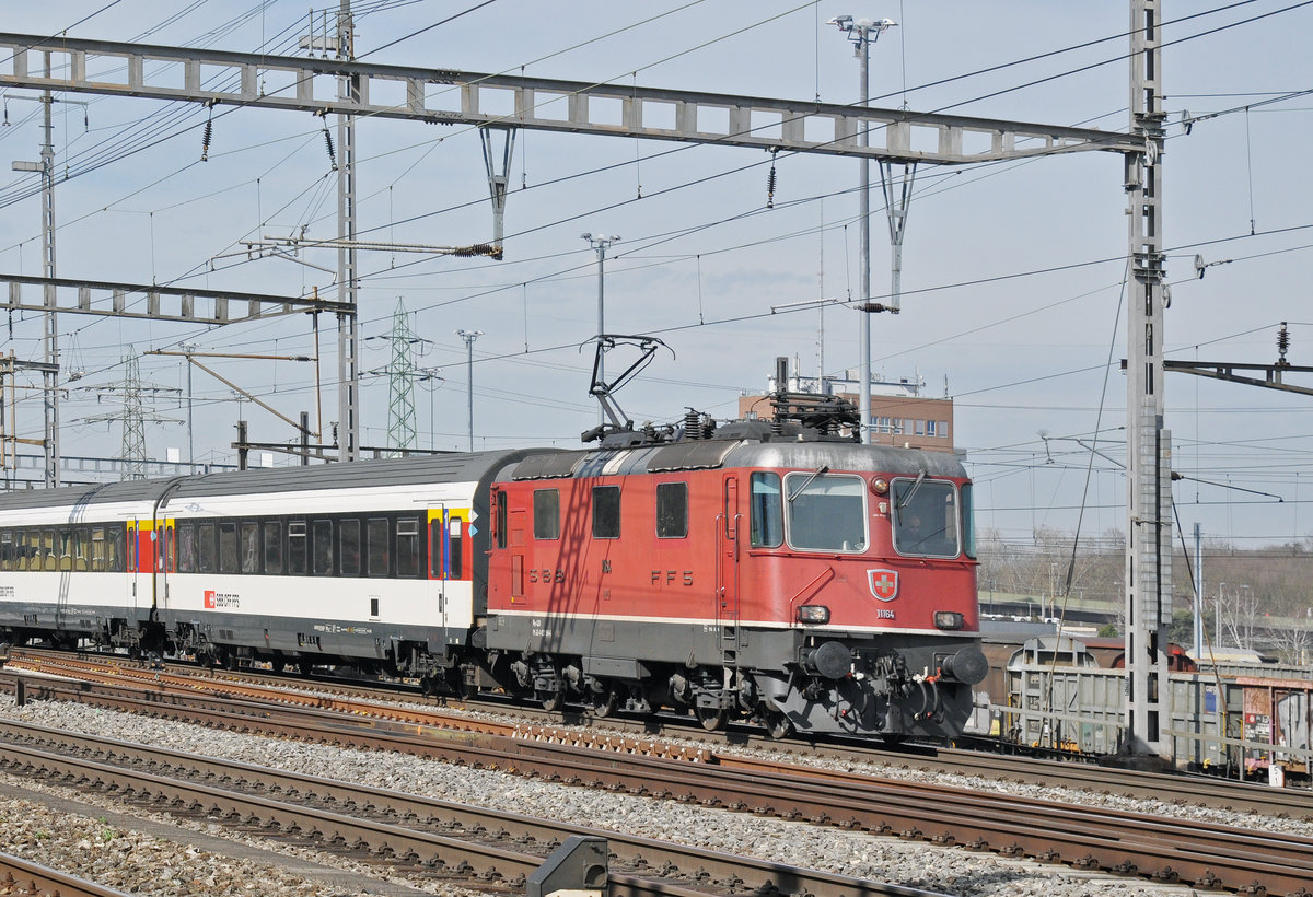 Re 4/4 II 11164 durchfährt den Bahnhof Muttenz. Die Aufnahme stammt vom 04.03.2017.