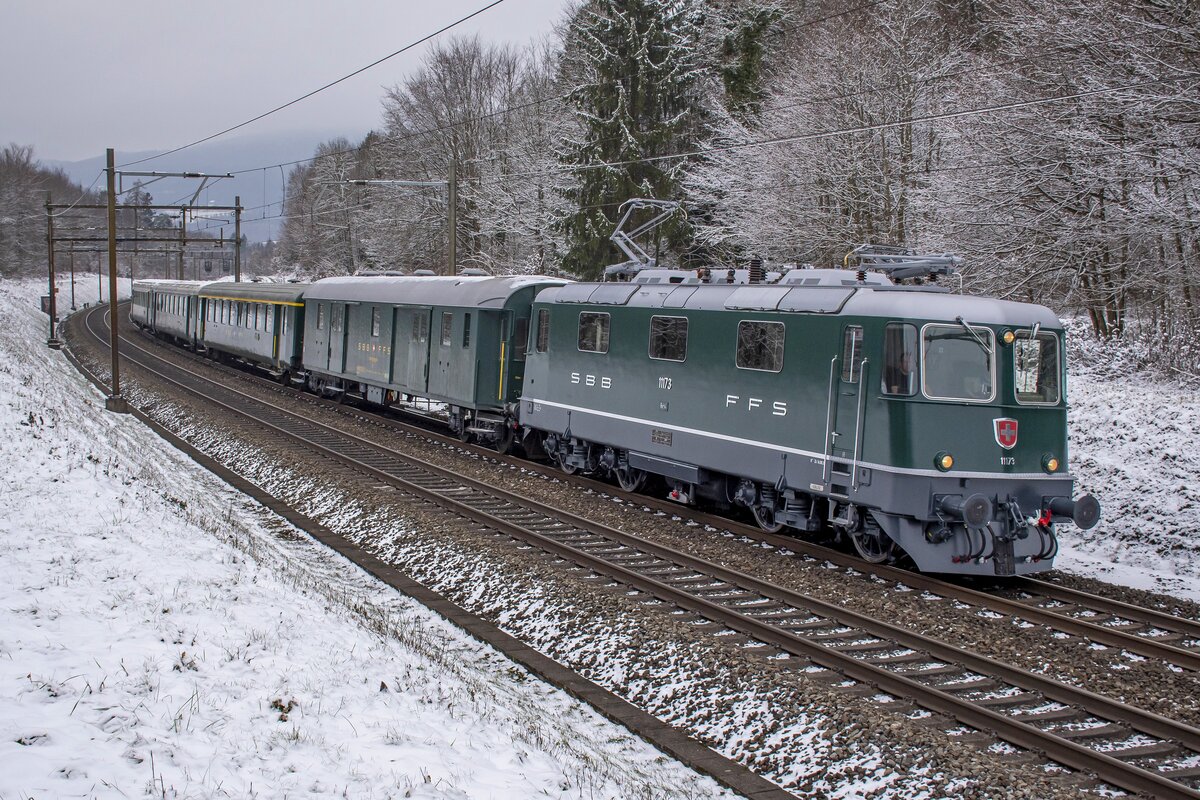 Re 4/4 II 11173 ist im Lenzburger Wald unterwegs in Richtung Zürich HB, aufgenommen am 18.12.2022.