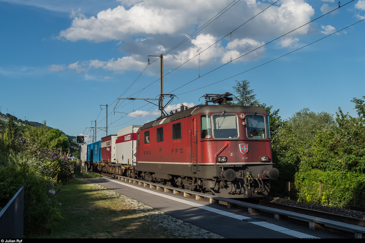Re 4/4 II 11190 durchfährt am 18. Juli 2016 mit einem kurzen Containerzug den Bahnhof Ligerz. Zu beachten gibt es auf dem Bild zudem das Vorsignal, welches entgegen der Fahrtrichtung offen ist.