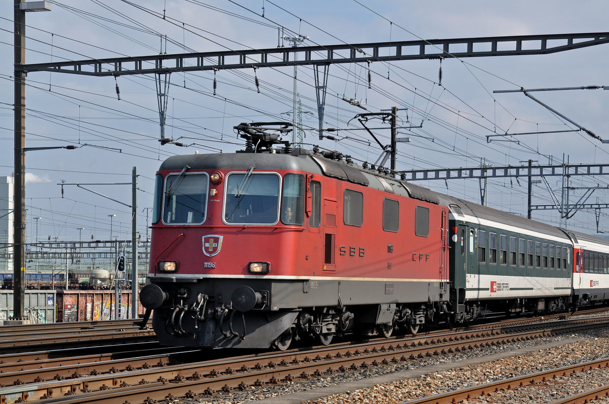 Re 4/4 II 11196 durchfährt den Bahnhof Muttenz. Die Aufnahme stammt vom 24.03.2016.