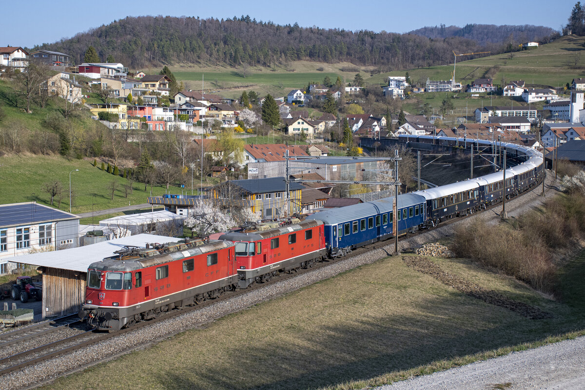 Re 4/4 II 11199 und 11191 ziehen den VSOE (Venice Simplon-Orient-Express) in Zeihen AG (CH) durch die  Fotokurve  in Richtung Basel. Aufgenommen am Abend des 27.03.2022. Beste Grüsse zurück in die Lok und danke für den Gruss.