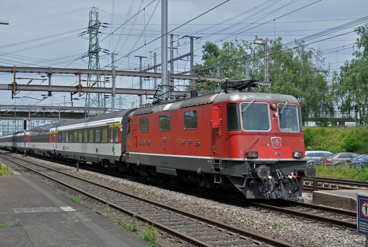Re 4/4 II 11199 durchfährt den Bahnhof Muttenz. Die Aufnahme stammt vom 22.06.2015.
